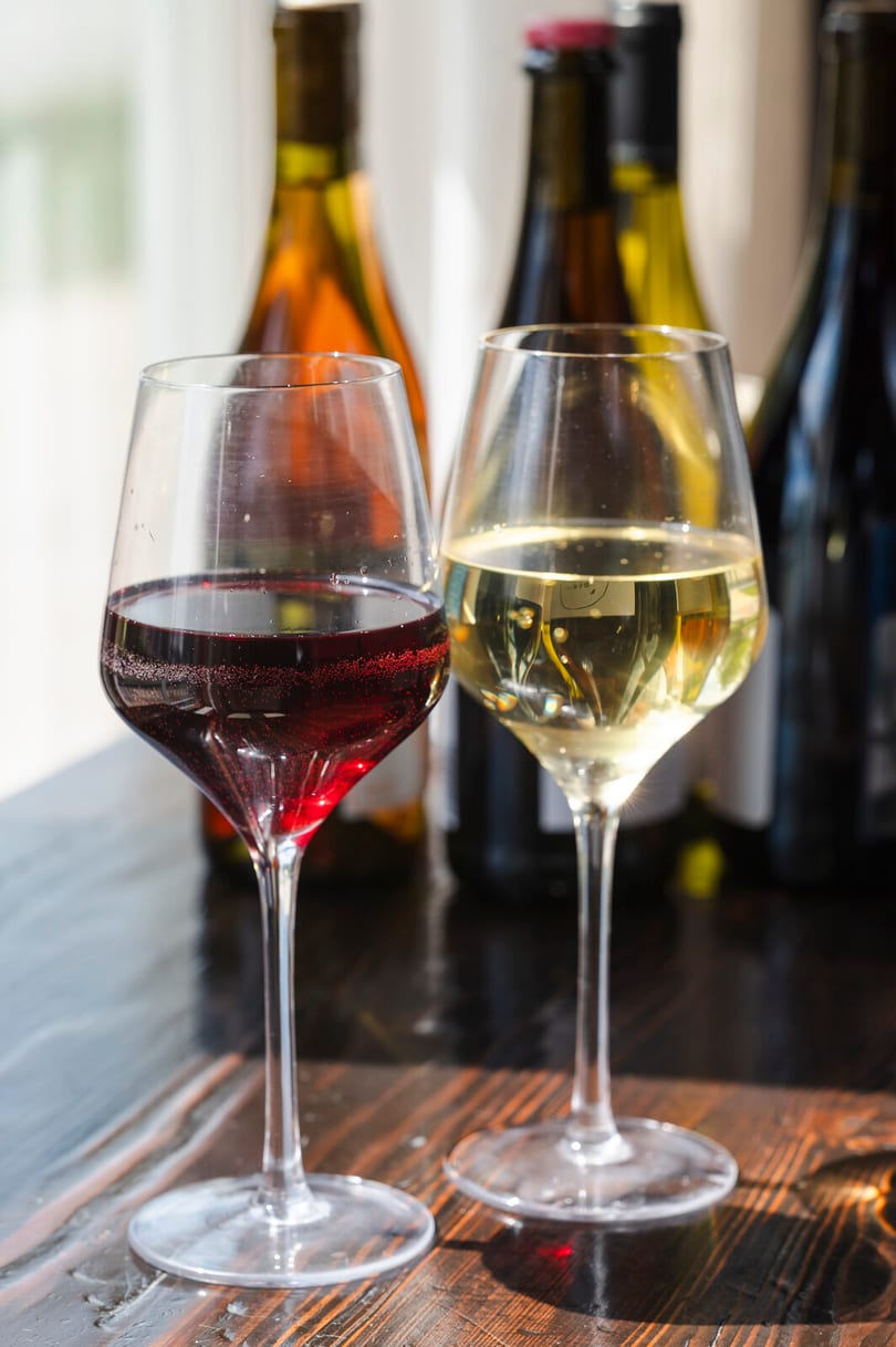 Two wine glasses on a wood table.
